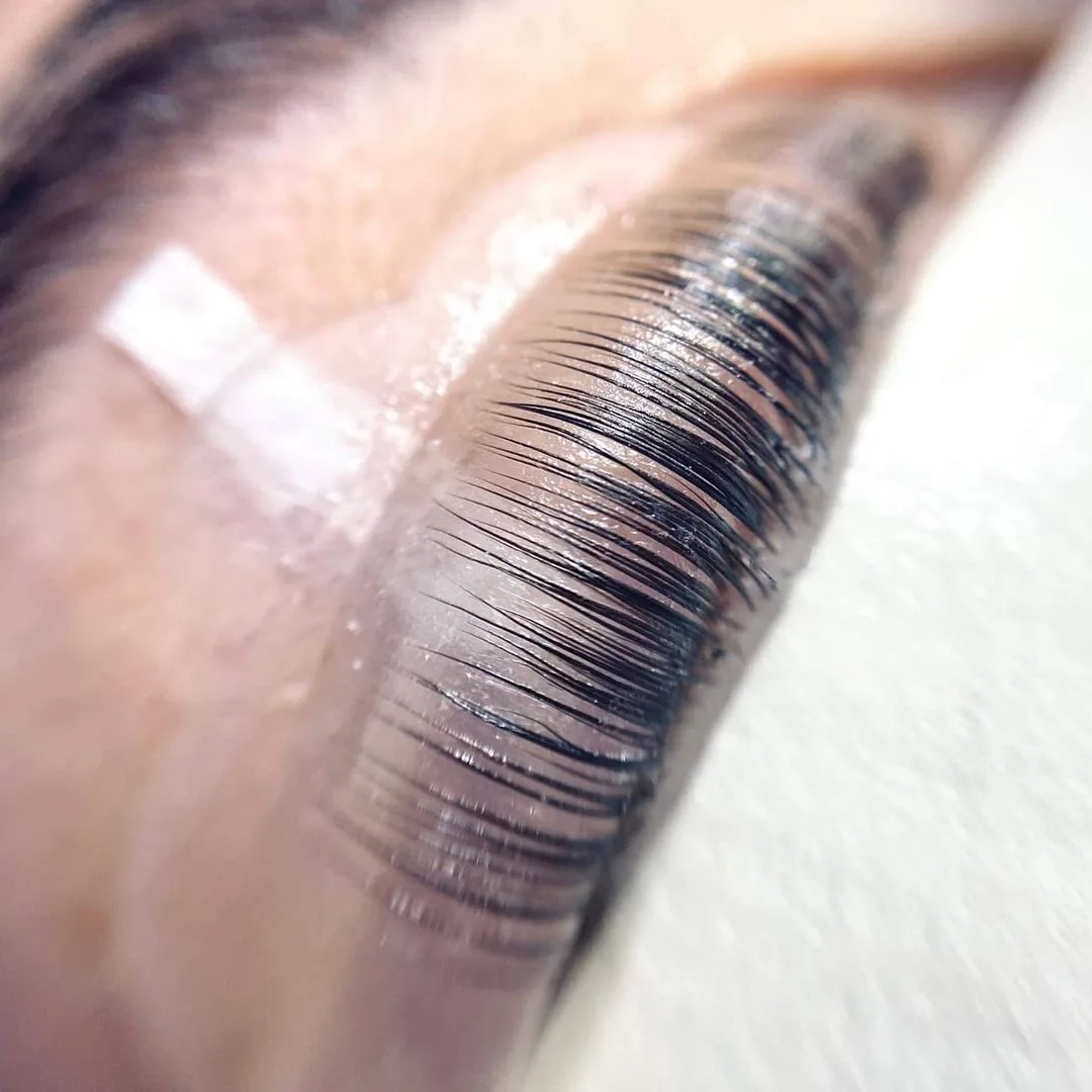 Lash lift behandling med løftede og adskilte vipper under laminering – close-up af naturlige vipper.